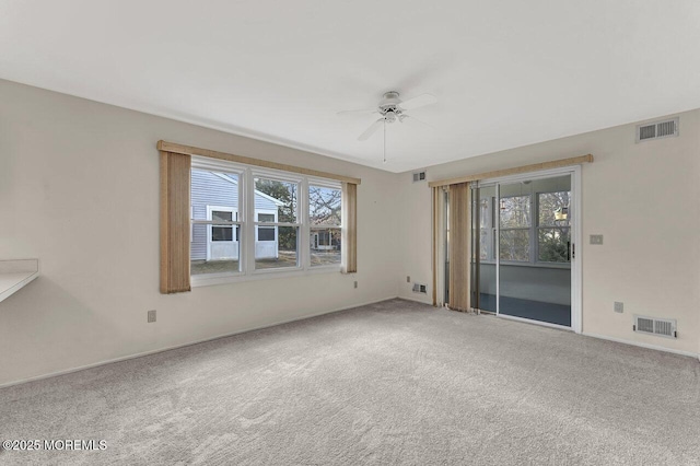 spare room with carpet flooring, a wealth of natural light, and ceiling fan