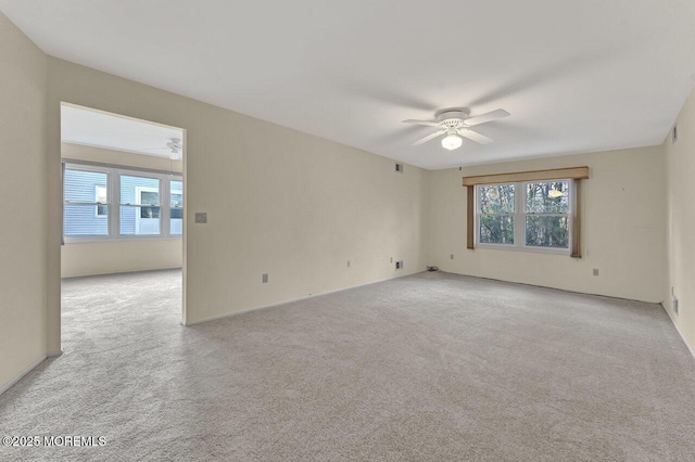 carpeted spare room featuring ceiling fan