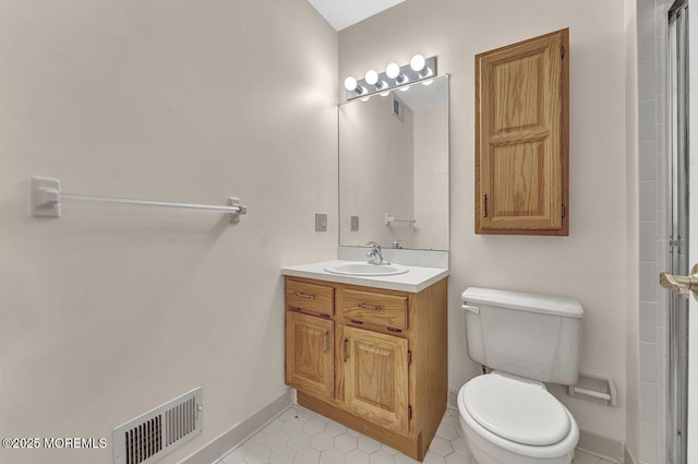 bathroom with tile patterned flooring, vanity, and toilet