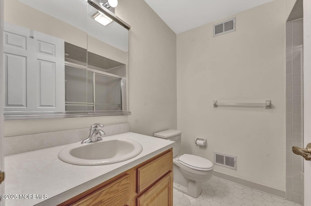 bathroom featuring tile patterned floors, vanity, toilet, and an enclosed shower