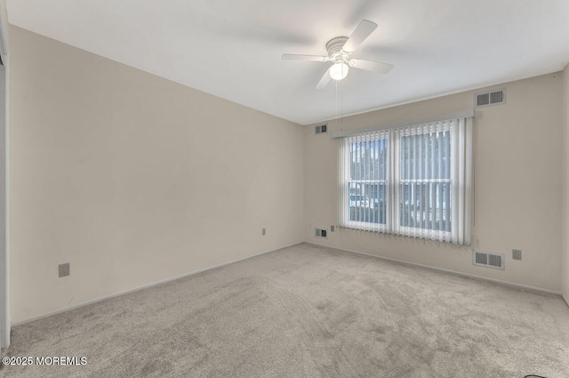 empty room featuring ceiling fan and light carpet