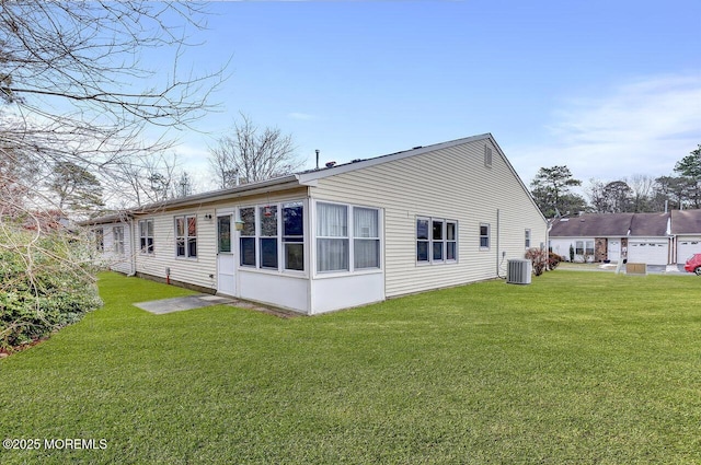 back of property with a lawn and central AC