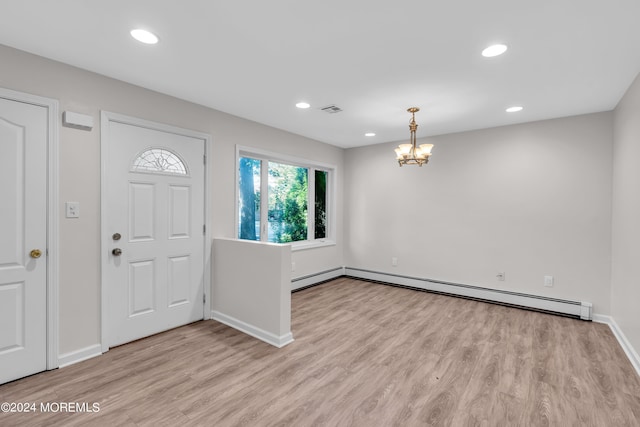 foyer entrance with light wood-type flooring, a baseboard radiator, and an inviting chandelier