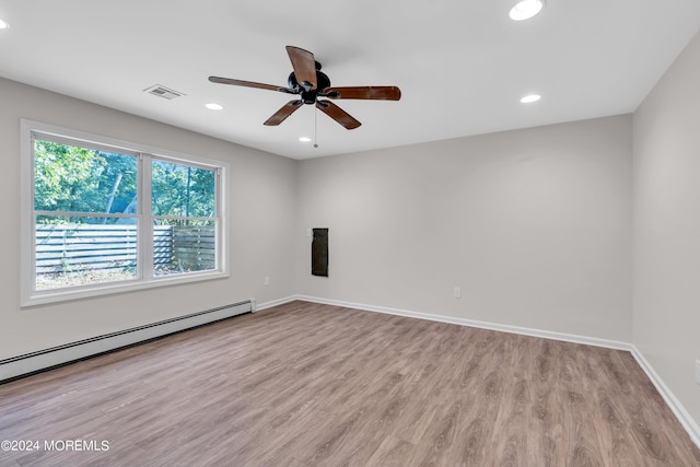 empty room with a baseboard radiator, light hardwood / wood-style flooring, and ceiling fan