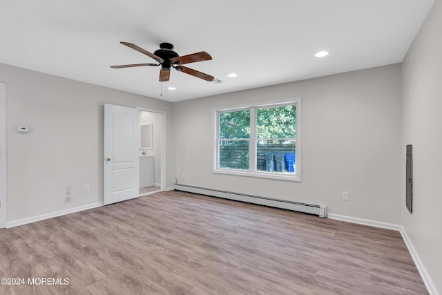 spare room featuring ceiling fan, light hardwood / wood-style floors, and a baseboard heating unit