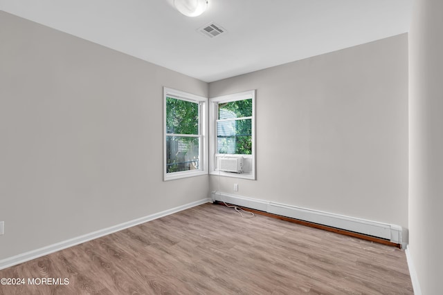 empty room featuring light hardwood / wood-style flooring and a baseboard heating unit