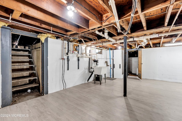 basement featuring sink and hardwood / wood-style flooring