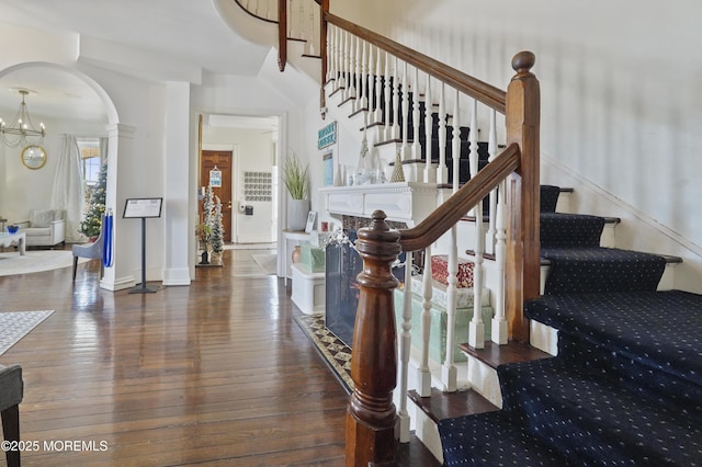 staircase with a notable chandelier and hardwood / wood-style flooring