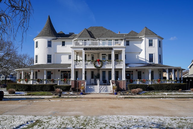 view of front of property featuring a balcony and a porch