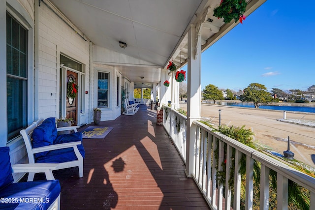 deck with a water view and a porch