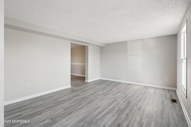 empty room with a textured ceiling and hardwood / wood-style flooring