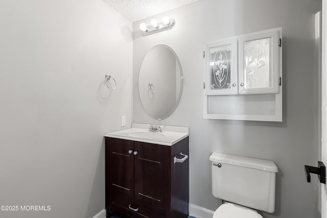 bathroom featuring toilet, vanity, and a textured ceiling