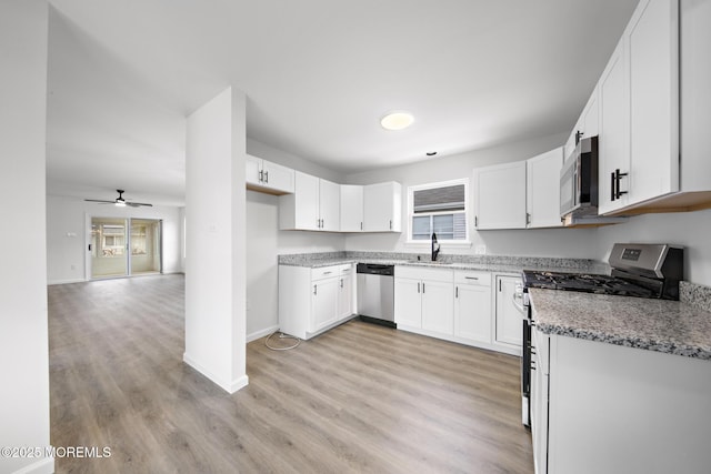 kitchen featuring white cabinetry, ceiling fan, stainless steel appliances, light stone counters, and light wood-type flooring