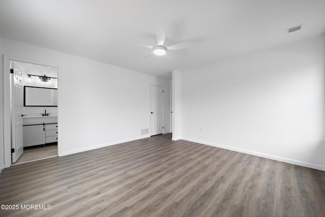 unfurnished bedroom with ceiling fan, wood-type flooring, connected bathroom, and a closet