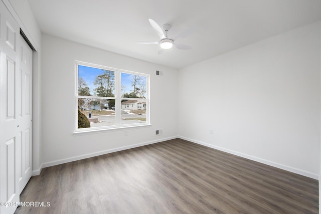 unfurnished bedroom featuring ceiling fan, dark hardwood / wood-style flooring, and a closet