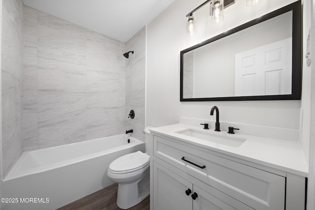 full bathroom featuring vanity, toilet, wood-type flooring, and tiled shower / bath combo