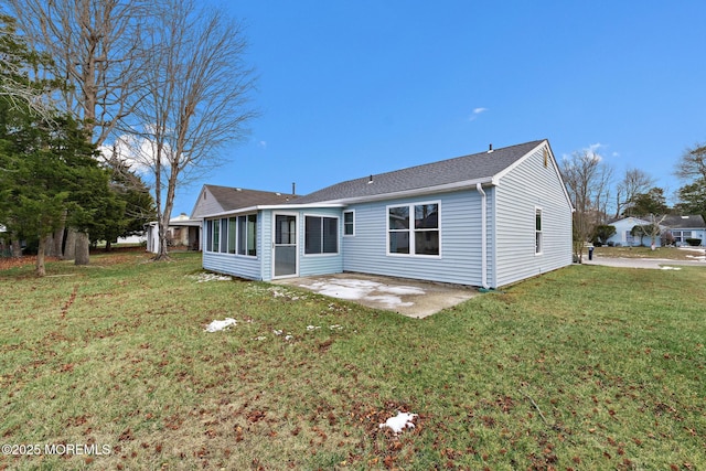 rear view of house featuring a yard, a patio, and a sunroom