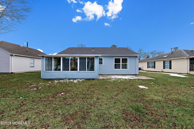 rear view of house featuring a lawn, a patio area, and a sunroom