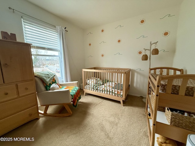 carpeted bedroom featuring a nursery area