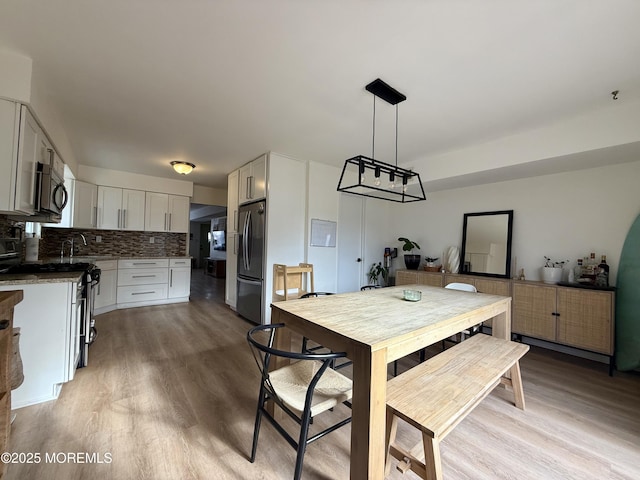 dining area featuring light hardwood / wood-style floors and sink