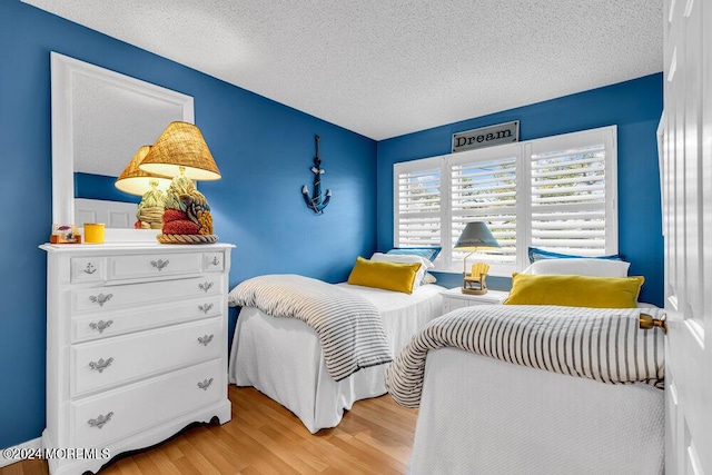 bedroom featuring a textured ceiling and light wood-type flooring