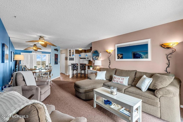 carpeted living room featuring a textured ceiling and ceiling fan