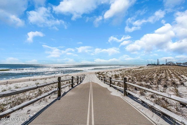 surrounding community with a beach view and a water view