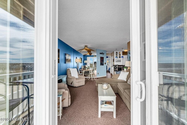 living room featuring a textured ceiling, ceiling fan, and carpet floors