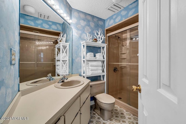 bathroom with a textured ceiling, an enclosed shower, vanity, and toilet