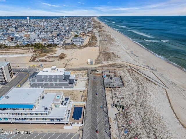 drone / aerial view featuring a water view and a view of the beach