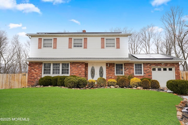 front of property featuring solar panels, a front lawn, and a garage