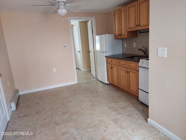 kitchen featuring sink, tasteful backsplash, a baseboard heating unit, white appliances, and light tile patterned floors