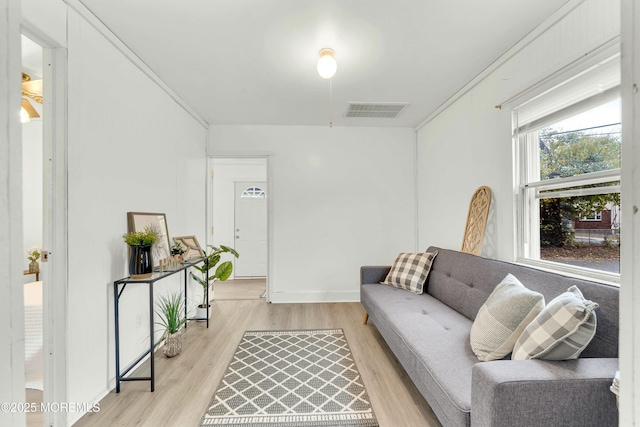 living room featuring ornamental molding and light hardwood / wood-style flooring