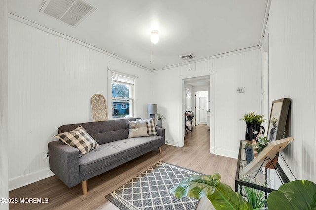 living room with hardwood / wood-style floors and ornamental molding