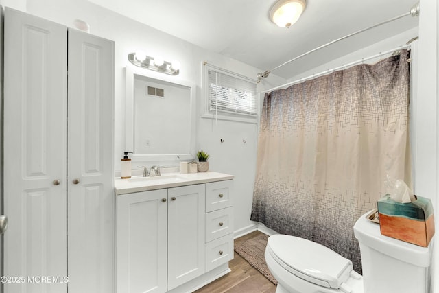 bathroom featuring toilet, vanity, hardwood / wood-style floors, and curtained shower