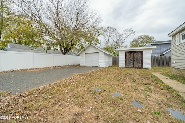 view of yard featuring a garage and a storage shed