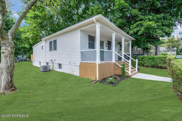 view of front of property with a front yard, central AC, and covered porch