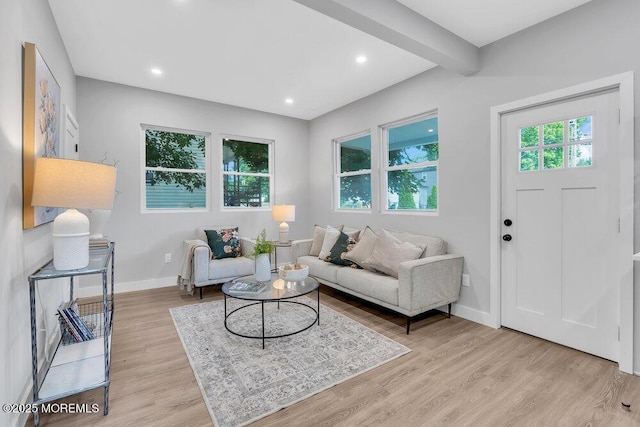 living room featuring light wood-type flooring and beamed ceiling