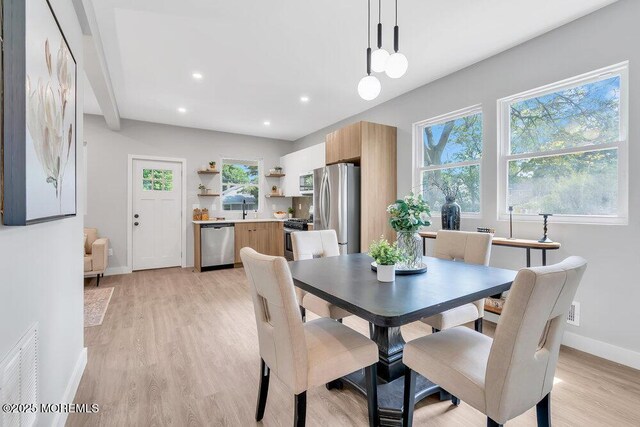 dining space featuring sink, light hardwood / wood-style floors, and plenty of natural light