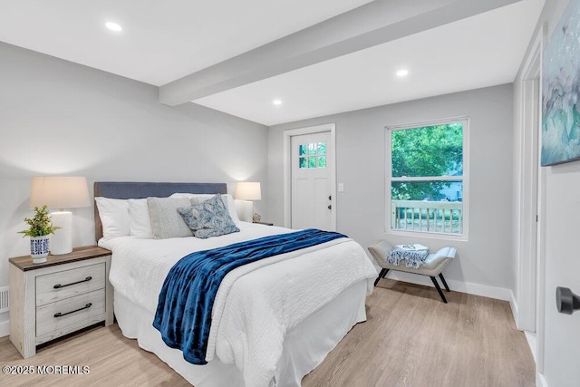 bedroom with beamed ceiling and light hardwood / wood-style flooring