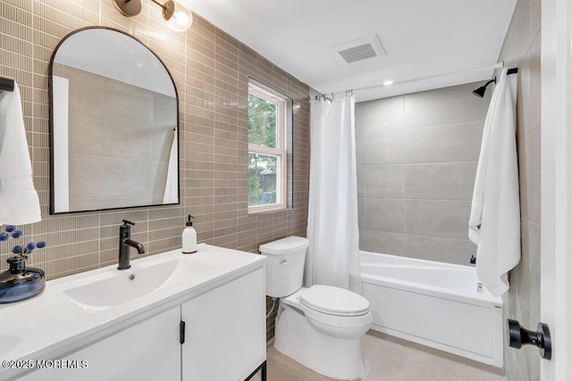 full bathroom with toilet, vanity, tile walls, and shower / bath combo with shower curtain