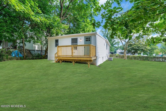 rear view of property with a deck and a yard