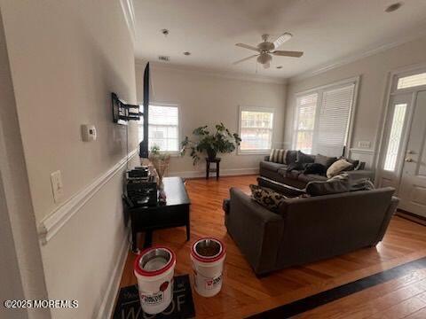 living room featuring ceiling fan, wood-type flooring, and crown molding