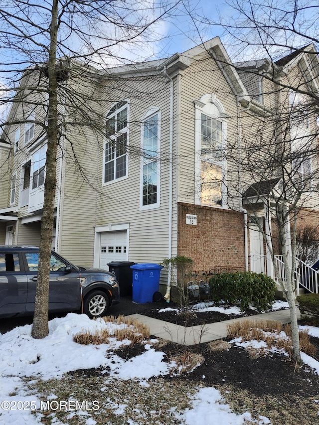 view of snowy exterior with a garage