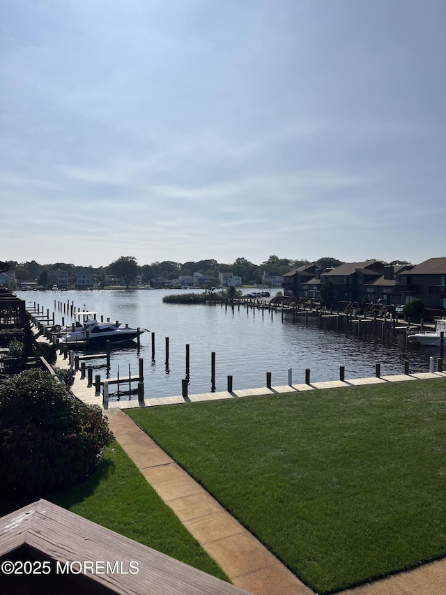 dock area with a yard and a water view