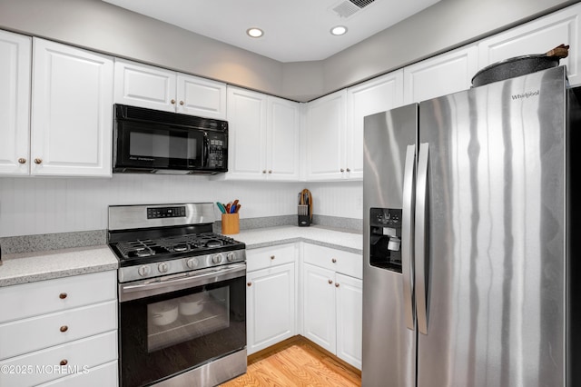 kitchen with white cabinetry, light hardwood / wood-style flooring, and appliances with stainless steel finishes