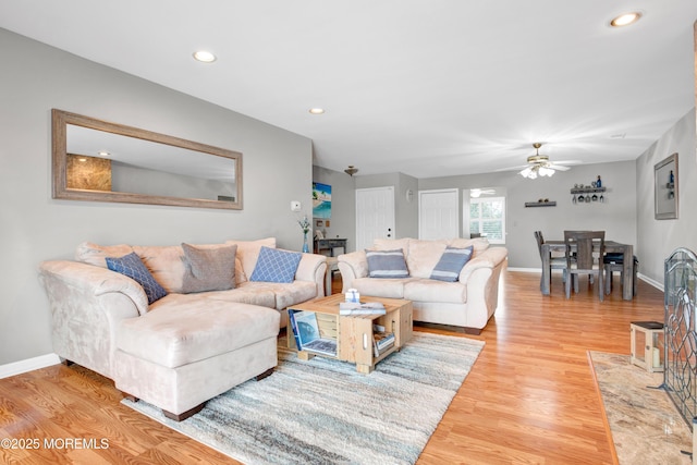 living room featuring ceiling fan and light hardwood / wood-style flooring