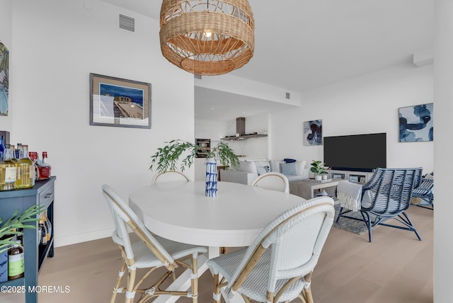 dining space with wood-type flooring