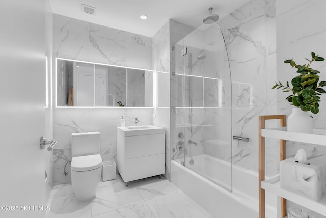 full bathroom featuring vanity, toilet, tile walls, and enclosed tub / shower combo