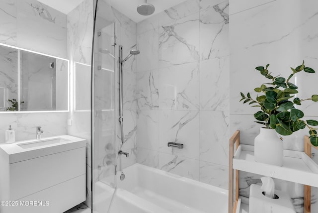 bathroom featuring vanity, tiled shower / bath combo, and tile walls